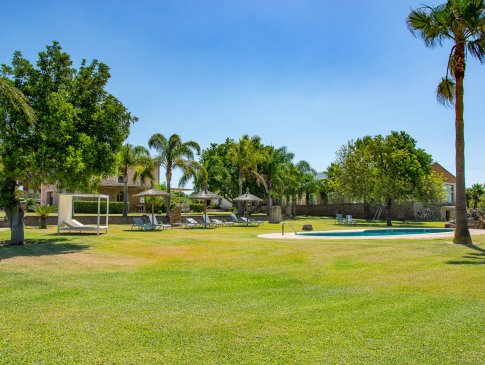 Weitläufiger parkähnlicher Garten mit lauschigen schattigen Plätzen rund um den Pool,