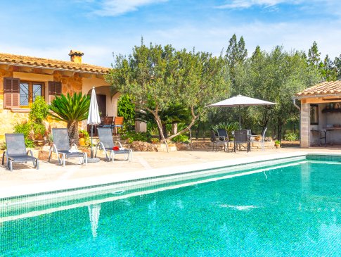 Blick vom Poolrand zu Wohnhaus mit Terrasse und Sonnenliegen und BBQ-Haus, Finca Son Garreta, Campanet