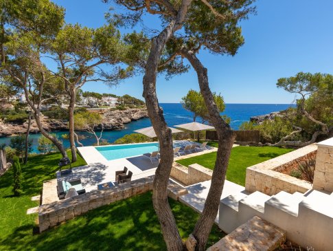 Außenbereich in Terrassen angelegt mit viel Rasen, Bäumen, Pool und Poolterrasse mit gemütlichen Outdoor-Möbeln, Villa Cala Ego, Cala D'Or
