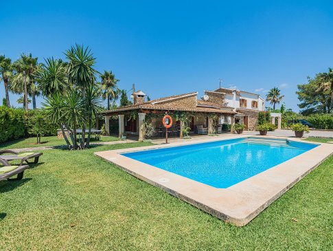 Pool umgeben von Rasenfläche und Garten mit Bäumen und Palmen, Finca Barretas, Pollensa